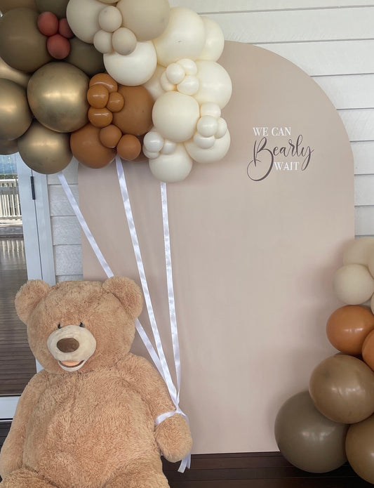 A bear-shaped balloon cluster with a mix of beige, gold, and brown colors, featuring text 'BEARY WAIT'.