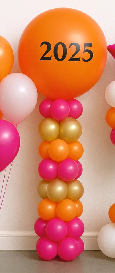 Colorful balloon arch with '2025' balloons against a white wall.